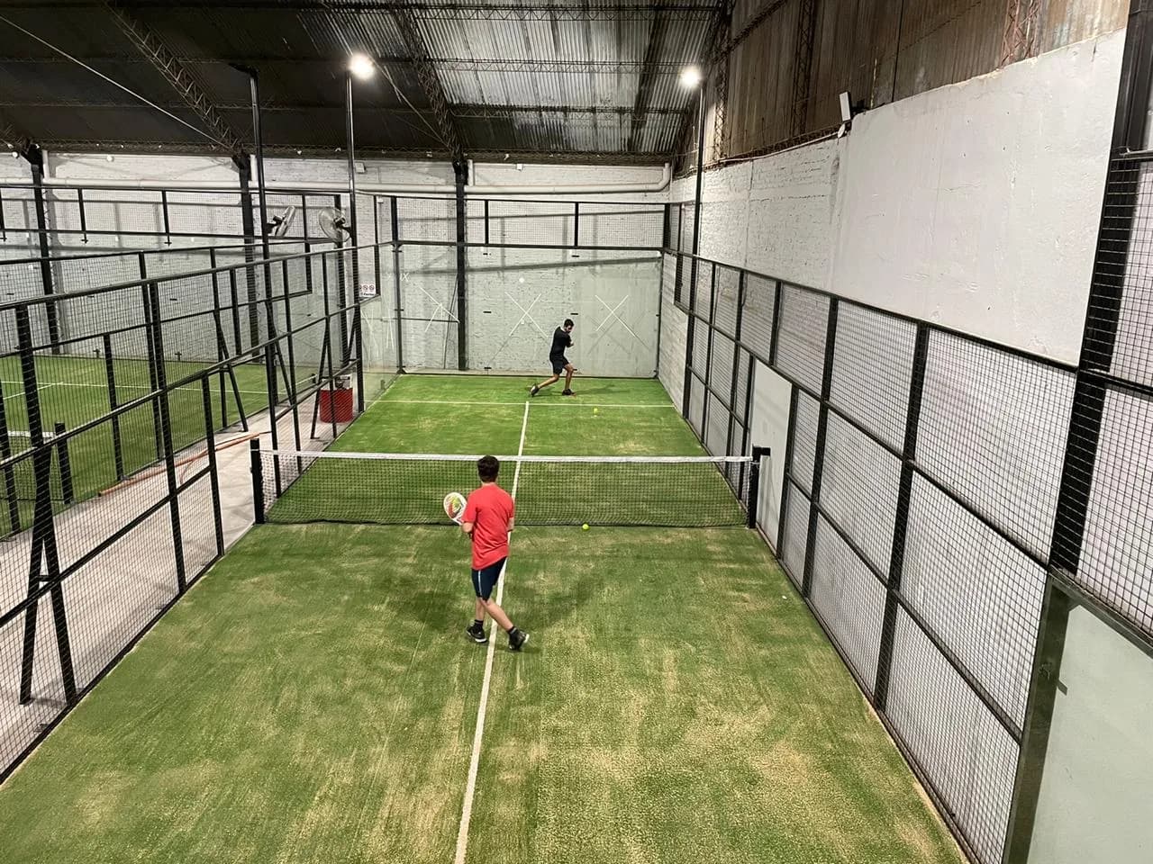 Dos jugadores en un partido en una de las canchas de césped del galpón
